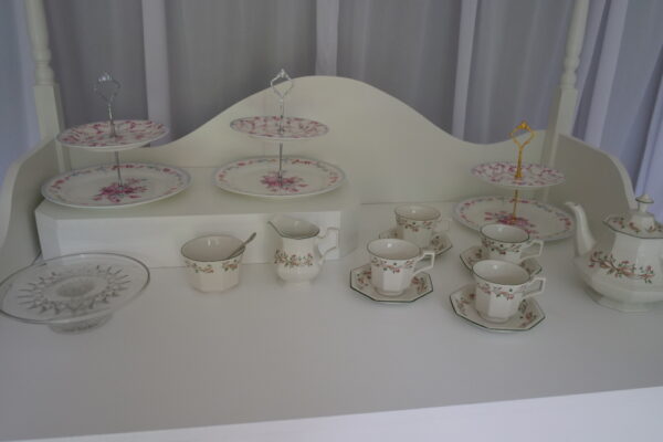 Image of teapot, 4 cups and saucers, a sugar bowl, a milk jug, and several cake stands