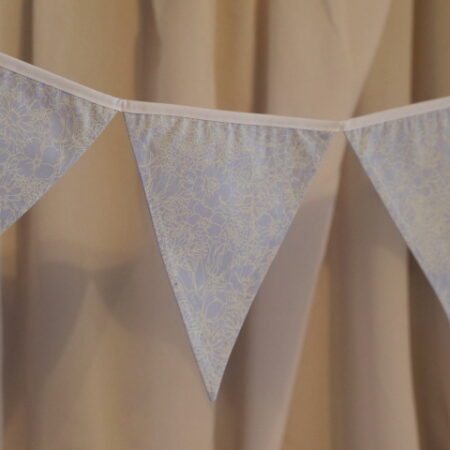 Light blue material triangle bunting with a flower pattern in white