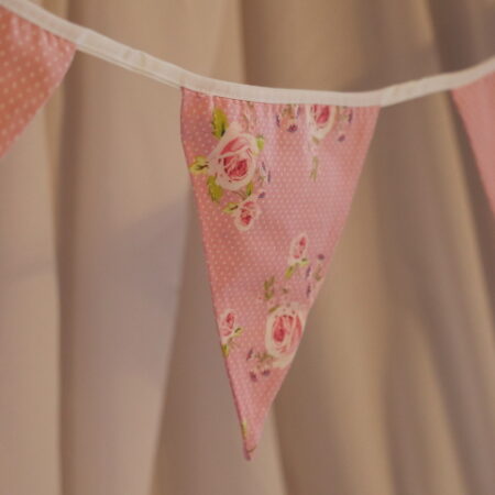 Pink polka dot material triangular bunting with pink rose floral pattern